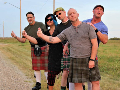 Tilted Kilts band publicity shot: one woman and four men wearing plaid and hitchhiking.